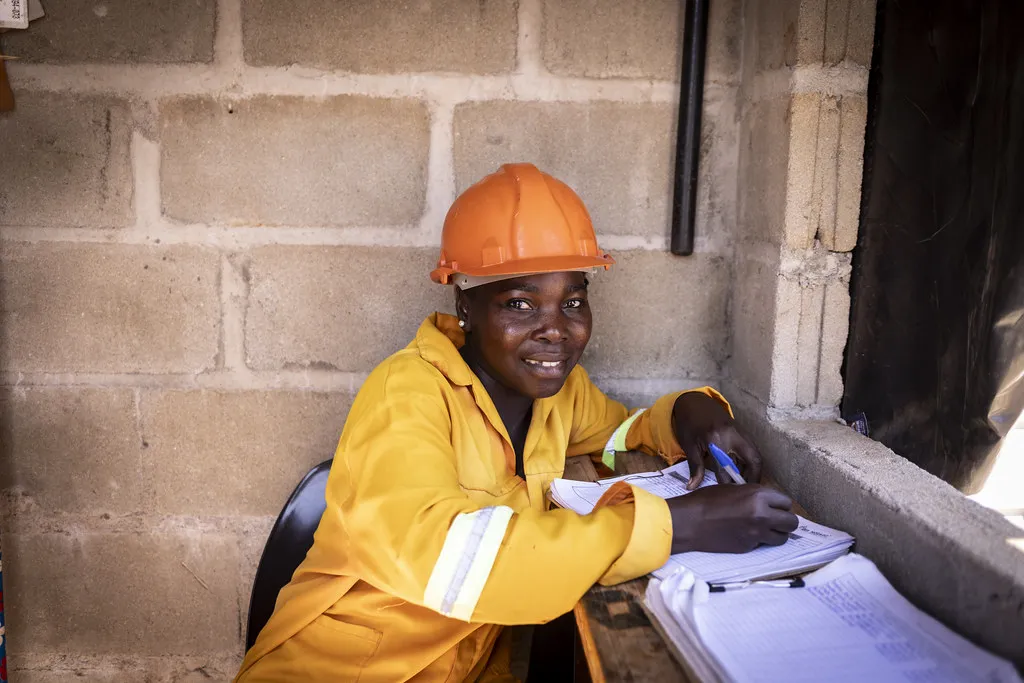 Technicienne en tenue de chantier prenant des notes sur site